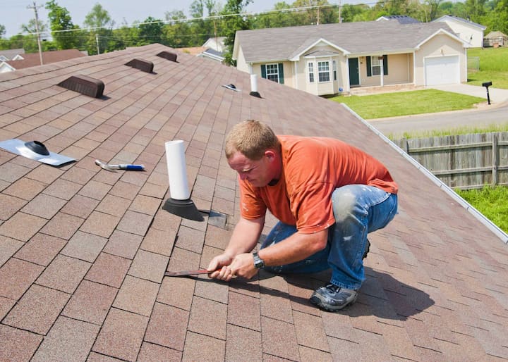A roof repair technician fixes shingles on a Santa Clarita home.
